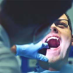 Man completing dental exam from dentist for toothache in Flint