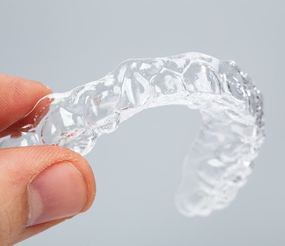 Hand holding an Invisalign tray