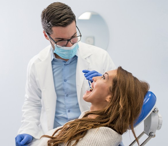 Dentist performing oral cancer screening