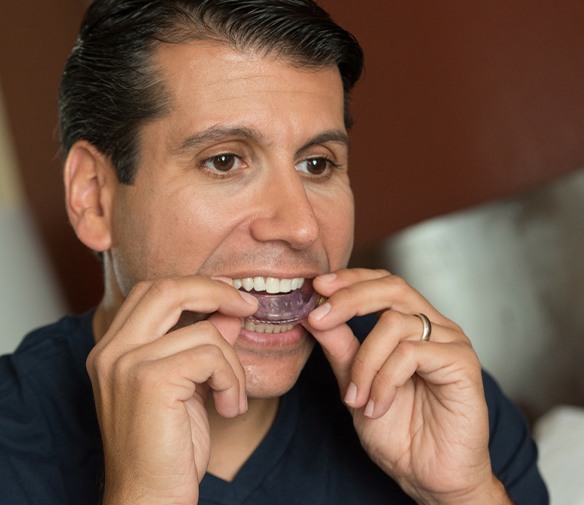 Patient placing oral appliance for sleep apnea treatment