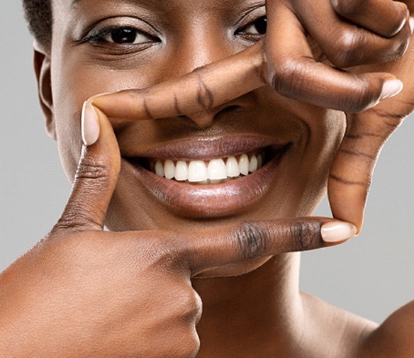 a person framing their smile with their hands